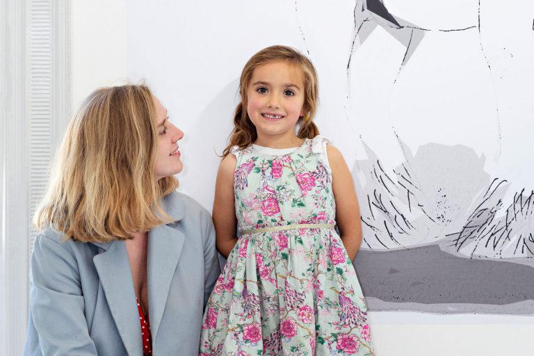 Adult and child in front of artwork.