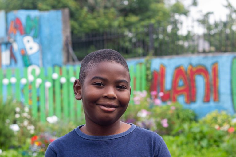 Child in colourfully designed community garden.