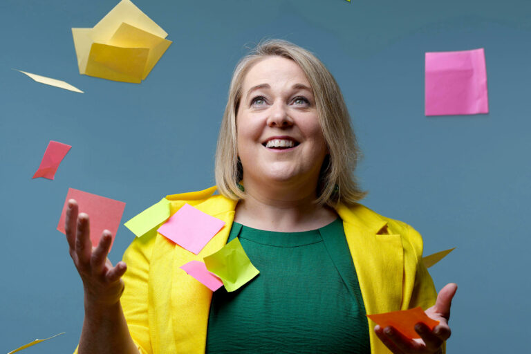 Woman looking up while post-its float in the air